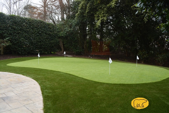 Greenwich Synthetic grass golf green with 4 holes and flags in a landscaped backyard